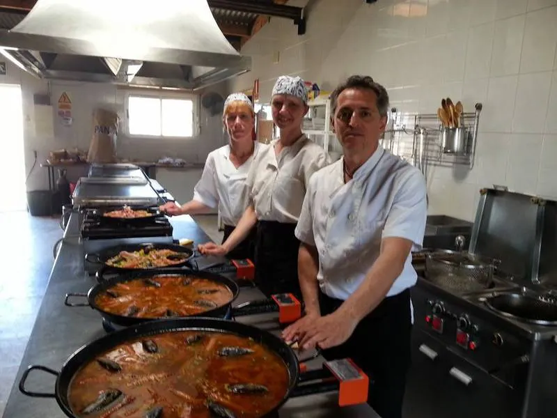 Cocineros de El Parque preparando paellas de pescado y marisco a fuego vivo en la cocina